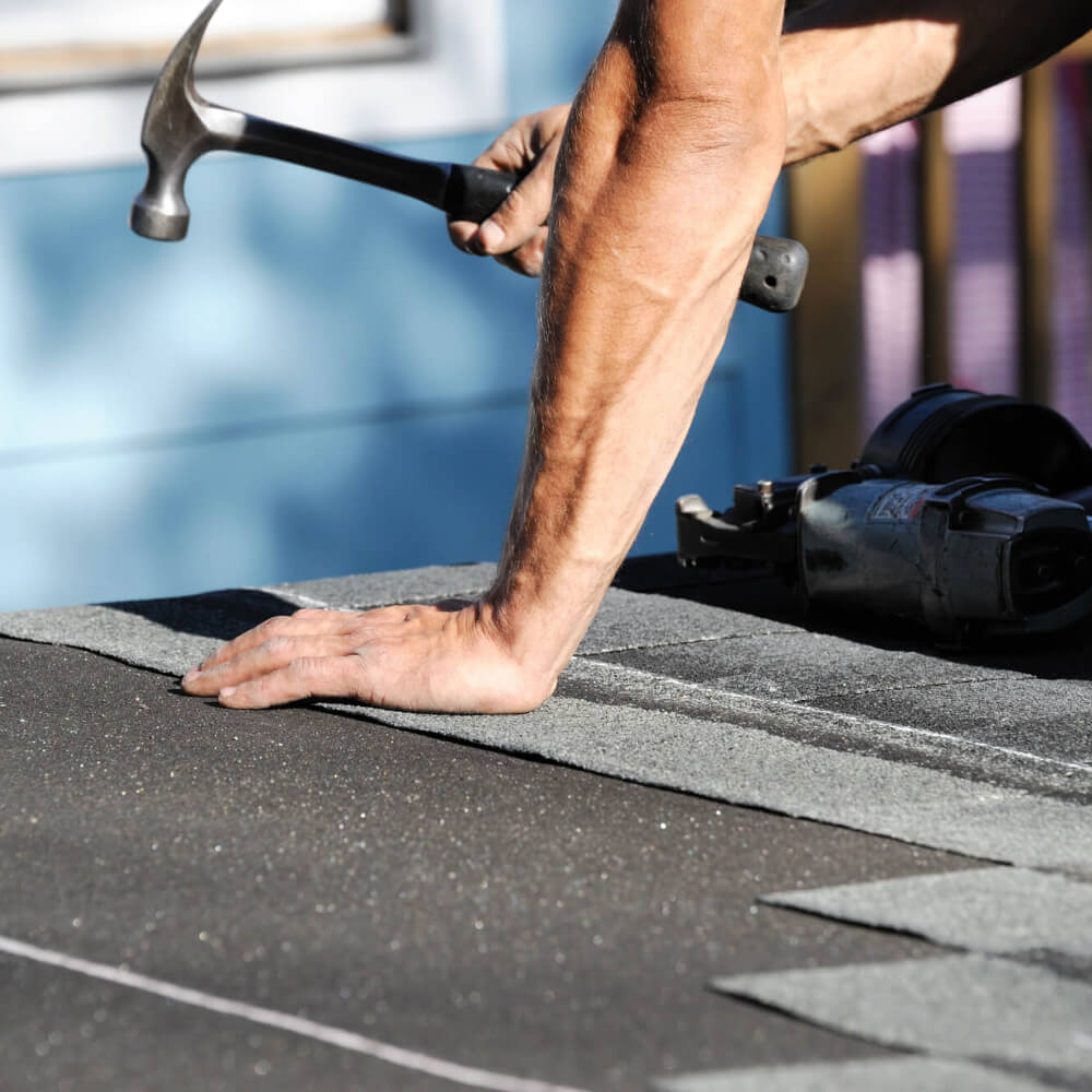 McCoy Roofing worker on a roof performing a roof replacement.