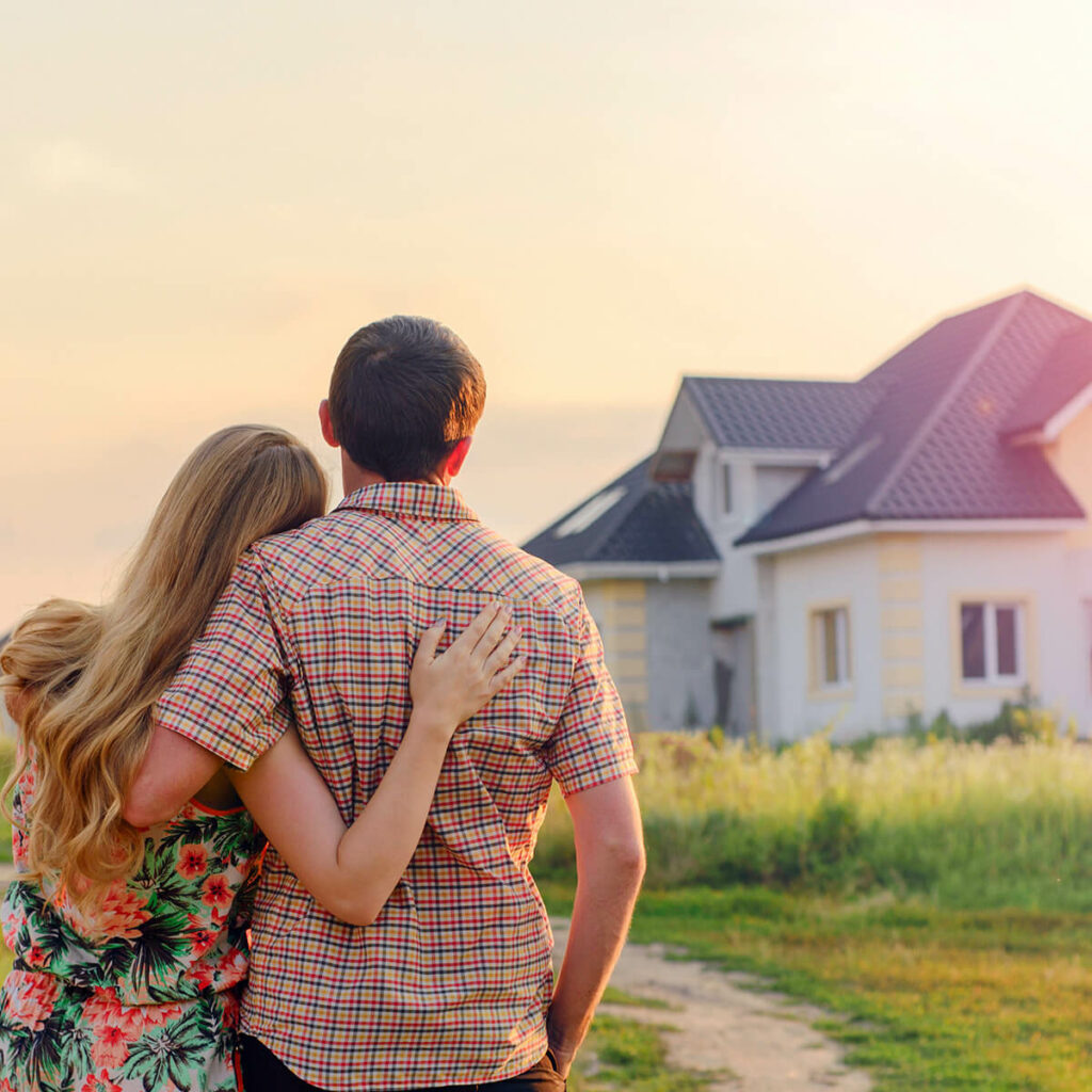 A couple in front of a house watching a new McCoy Roofing Roof.