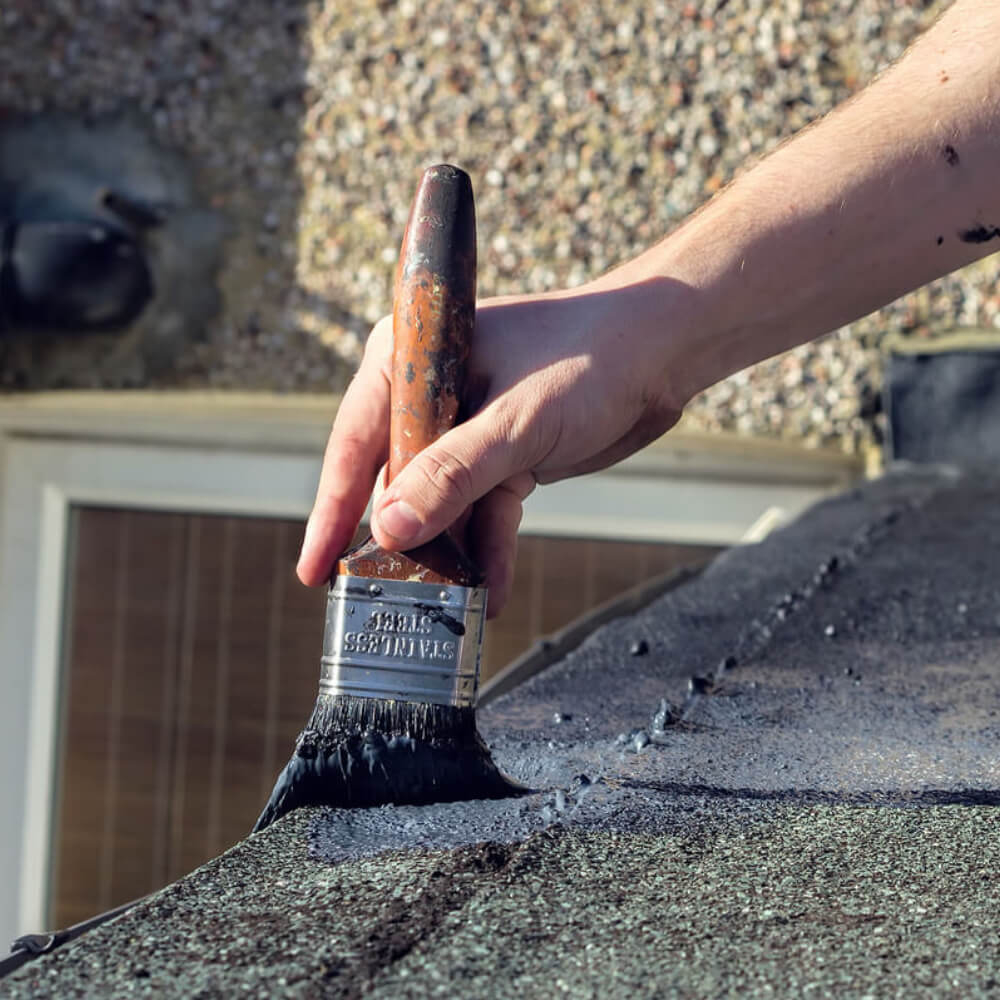 Picture of a McCoy Roofing worker applying roofing felt on a roof's maintenance service. 