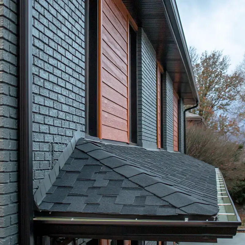 The overhang of a homes roof material using asphalt shingles from GAF.